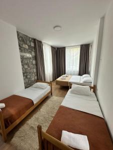 Habitación con 2 camas y sala de estar. en Hotel Vellezrit Guri, en Theth