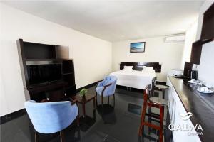 a hotel room with a bed and a table and chairs at Qallwa Chincha in Chincha Alta