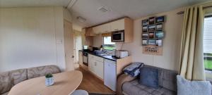 a living room with a couch and a table in a caravan at Coastal Retreat Newquay NB91 in Newquay