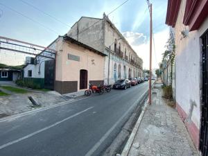uma rua com carros estacionados ao lado de um edifício em Hostal Villa Sabila em Santa Ana