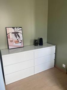 a white dresser with a picture on top of it at Charmante maison de ville in Bourges