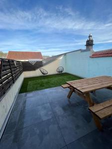 a patio with a wooden picnic table on a building at Charmante maison de ville in Bourges