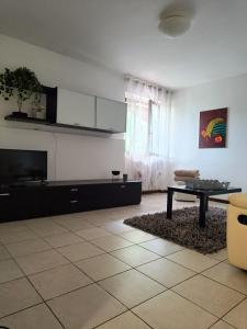 ein Wohnzimmer mit einem TV und einem Tisch in der Unterkunft MANZONI APARTS - Comfort SUITE in San Pellegrino Terme