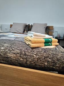 einen Haufen Handtücher auf einem Bett in der Unterkunft MANZONI APARTS - Comfort SUITE in San Pellegrino Terme