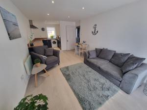 a living room with a couch and a table at Waterfront Retreat - Modern Apartment in Burnham on Crouch