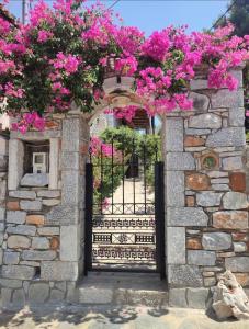 una puerta en una pared de piedra con flores rosas en Villa Pasas, en Koíta