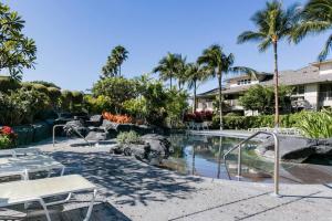 una piscina en un complejo con palmeras en Five Star Waikoloa Beach Villa, Golf & Lake Views, en Waikoloa
