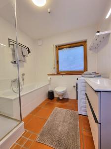 ein Badezimmer mit einer Badewanne, einem WC und einem Waschbecken in der Unterkunft Ferienhaus Heckler in Bad Camberg