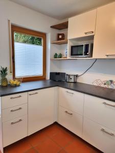 eine Küche mit weißen Schränken und einem Fenster in der Unterkunft Ferienhaus Heckler in Bad Camberg