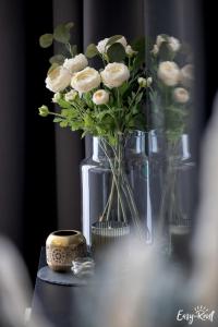 wazon wypełniony białymi kwiatami na stole w obiekcie Perfekt SPA w Dziwnowie
