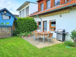 eine Terrasse mit einem Tisch, Stühlen und einem Grill in der Unterkunft Ferienhaus Heckler in Bad Camberg