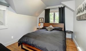 1 dormitorio con cama y ventana en Chalets Alpins - 38 Chemin des Skieurs, en Stoneham