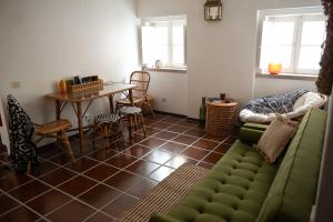a living room with a green couch and a table at Private Terrace Refúgio in Sesimbra