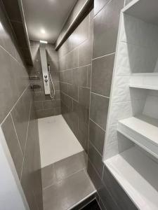 bagno con cabina doccia e piastrelle grigie di Aurillac T3 lumineux et rénové ad Aurillac