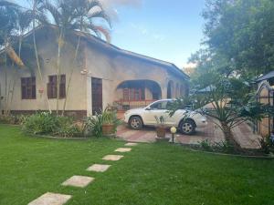 a white car parked in front of a house at Maasaifari Moshi 36 in Moshi