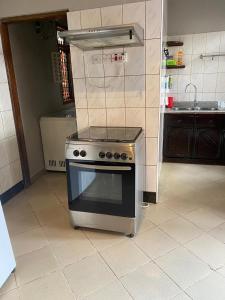 a kitchen with a stove top oven sitting on a tiled floor at Maasaifari Moshi 36 in Moshi