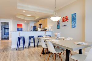 a kitchen and dining room with a table and chairs at Oceanfront Resort Condo with Private Beachwalk! in Dauphin Island