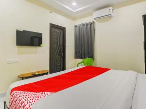 1 dormitorio con 1 cama y TV en la pared en SRI NIRVANA PRIDE, en Ibrāhīmpatan