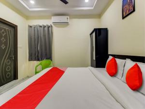 sypialnia z dużym łóżkiem z czerwonymi poduszkami w obiekcie SRI NIRVANA PRIDE w mieście Ibrāhīmpatan