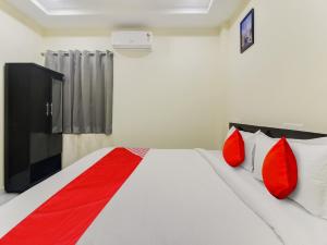 una camera da letto con un letto con cuscini rossi di SRI NIRVANA PRIDE a Ibrāhīmpatan