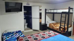 a room with two bunk beds and a flat screen tv at Hotel La Posada in Belén de Umbría