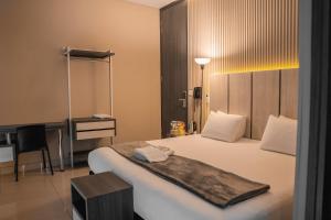 a hotel room with a large bed with a desk at HOTEL NABU VALLEDUPAR in Valledupar