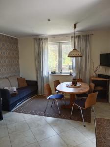 een woonkamer met een tafel en een bank bij Niebieski dom in Białogóra