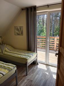 een kamer met twee bedden en een groot raam bij Niebieski dom in Białogóra
