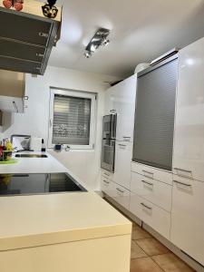 een keuken met witte werkbladen en een raam met een blinde bij FireApart in Rednitzhembach