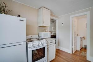 a white kitchen with a stove and a microwave at Lakeshore Cabin 2 dock, boat slip and patio in Lake Ozark