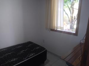 um quarto com uma cama e uma janela em Casa agradável em meio a natureza. em Santa Cruz Cabrália