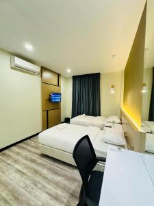 a hotel room with two beds and a table at STAR HOTEL in Tawau