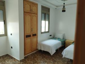 Un dormitorio con una cama y un armario. en Appartement Hajar, en Oualidia