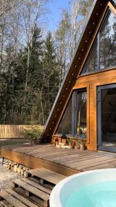 una casa con bañera de hidromasaje en una terraza de madera en Haus im Wald, en Lindig