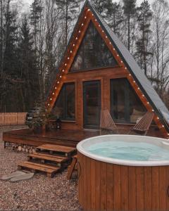 Cabaña de madera con bañera de hidromasaje en el patio en Haus im Wald, en Lindig