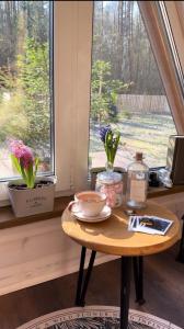 una mesa frente a una ventana con flores. en Haus im Wald, en Lindig