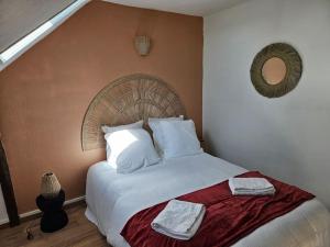 a bedroom with a bed with two towels on it at Rêve de Loire in La Daguenière