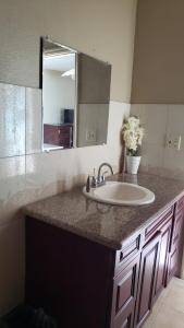 a bathroom counter with a sink and a mirror at Home Away From Home in Nassau