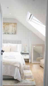 a white bedroom with a bed and a mirror at Oakleigh House, 3 bedroom, free parking in East Barnet