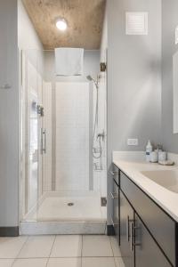 a white bathroom with a shower and a sink at Indoor Pool Gym Rooftop-215-by Cloud9 in Chicago