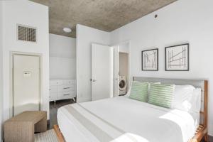 1 dormitorio con 1 cama blanca grande con almohadas verdes en Indoor Pool Gym Rooftop-215-by Cloud9, en Chicago