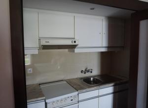 uma cozinha com armários brancos e um lavatório em Apartamento Villa Galé Cascais em Cascais