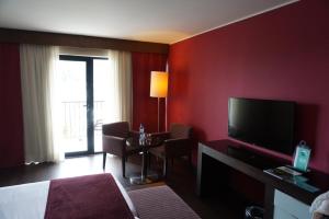 ein Hotelzimmer mit einem Bett und einem TV in der Unterkunft Apartamento Villa Galé Cascais in Cascais