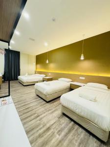 una habitación de hotel con 3 camas en una habitación en STAR HOTEL, en Tawau