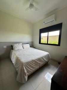 um quarto com uma cama grande e uma janela em Casa para Agrishow em Ribeirão Preto