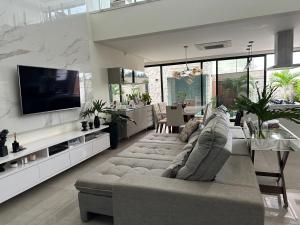 uma grande sala de estar com um sofá e uma televisão em Casa para Agrishow em Ribeirão Preto