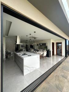 eine Küche und ein Esszimmer mit einem großen Fenster in der Unterkunft Casa para Agrishow in Ribeirão Preto