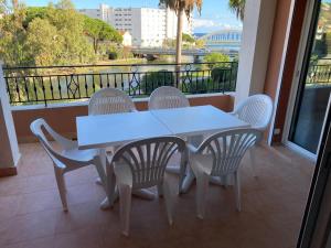Una mesa blanca y sillas en un balcón con vista. en Ste Maxime T3 Terrasse vue mer et avec piscine, en Sainte-Maxime