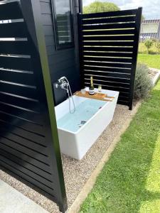 a bath tub with a shower in a yard at Soul Sanctuary, with outdoor bath in Raglan