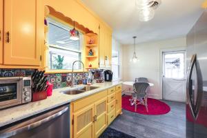 a kitchen with yellow cabinets and a sink at Colorful Roanoke Vacation Rental with Hot Tub! in Roanoke